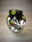 A Moorcroft pottery lidded ginger jar in the 'Japanese Honeysuckle' pattern, 6.25 ins high (16 cms)