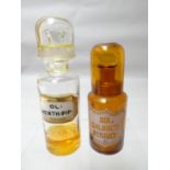 A brown glass covered re-agent bottle (labelled) together with a clear glass version (labelled)