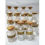 A good collection of early clear glass pharmaceutical bottles with cork and linium stoppers and each