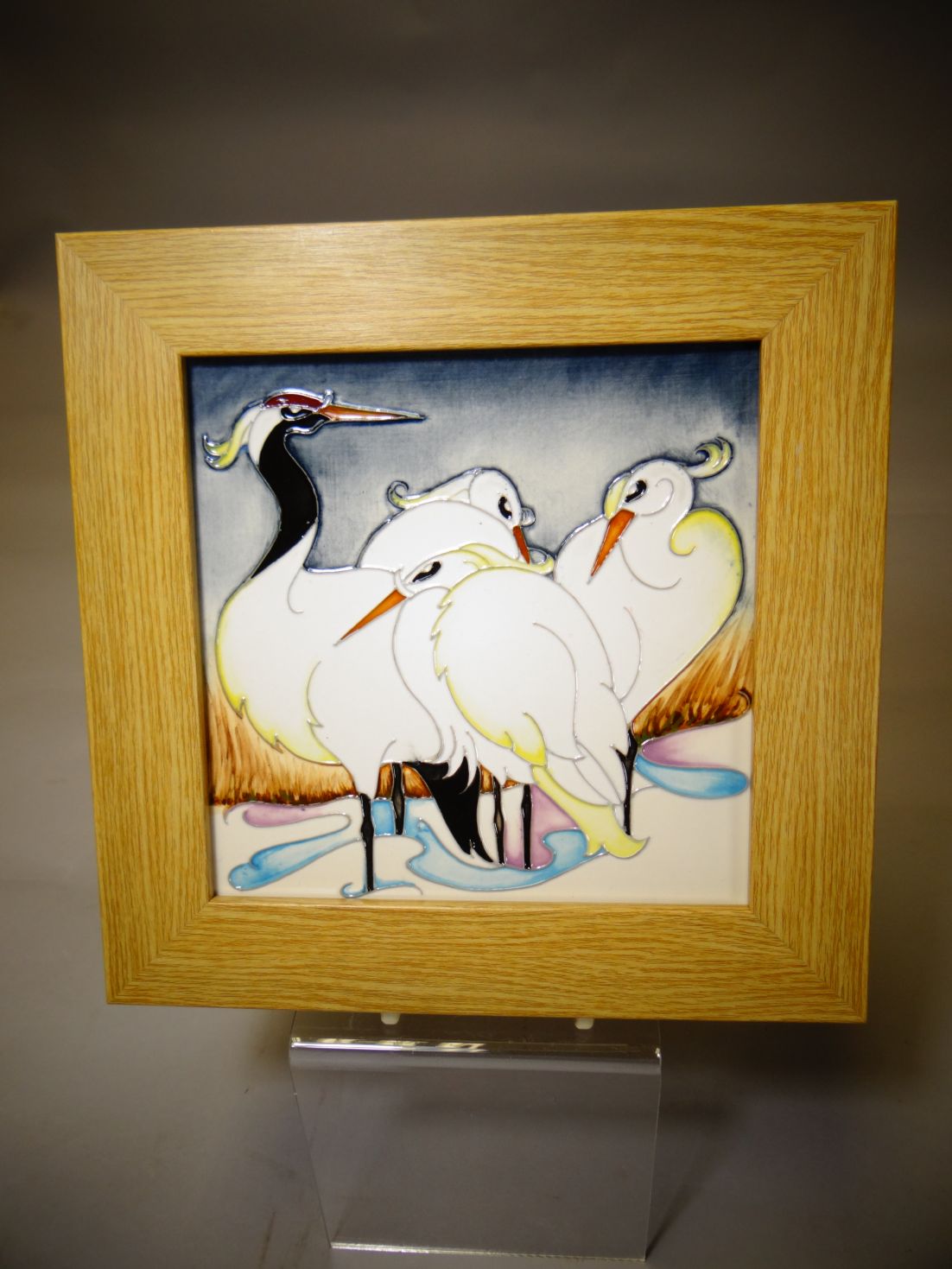 A Moorcroft pottery framed tile 'Snow Ballerinas', 8 x 8 ins (20 x 20 cms)