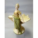 A Royal Dux jardiniere in the form of a maiden leaning upon a giant clam on a naturalistic base