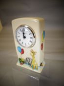 A Moorcroft pottery nursery clock decorated with children's toys and balloons