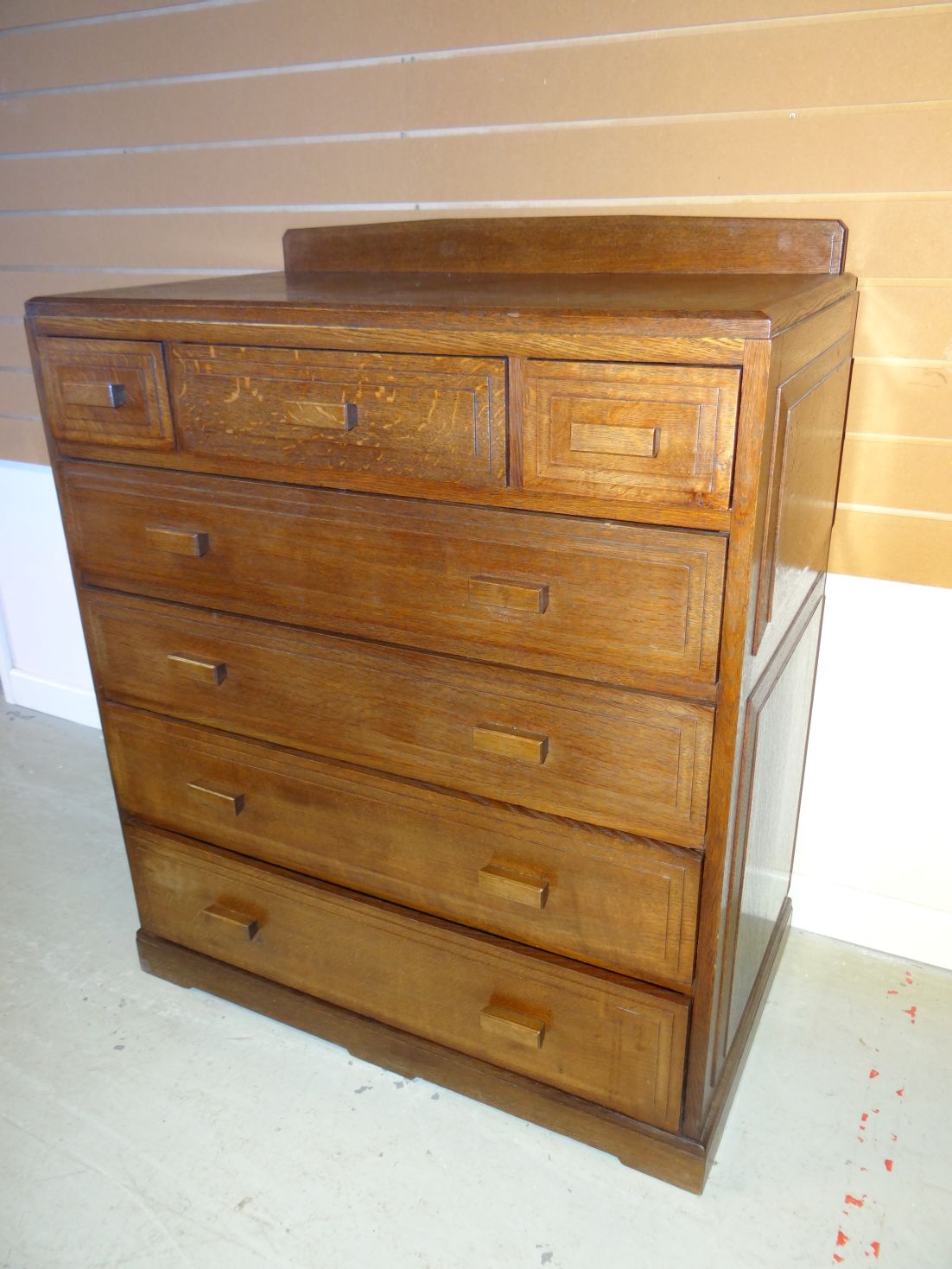 A dark oak Brynmawr Furniture 'Govilon' chest of four long and three short panelled drawers, 35.5