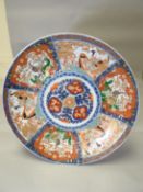 A large turn of the century Imari shallow charger-dish typically decorated with centre floral
