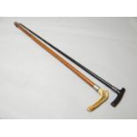 An ebonised walking cane with silver ferrule and another with horn handle