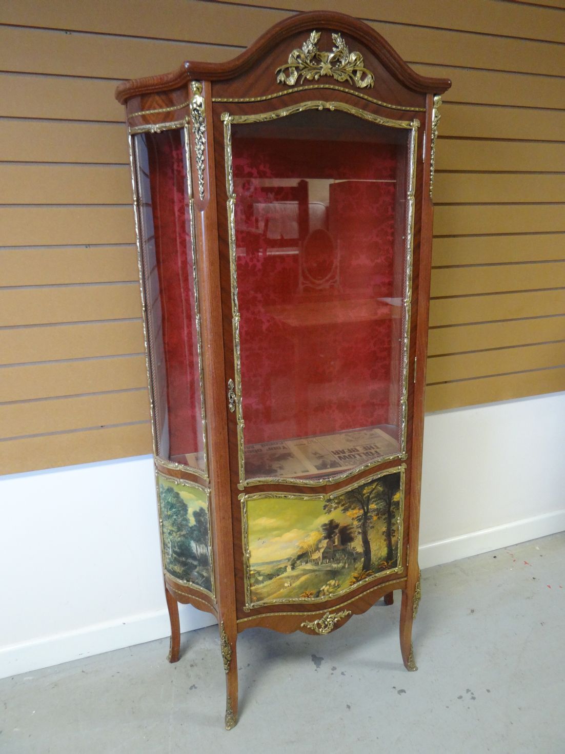 A reproduction vitrine cabinet with single glazed door with landscape printed panel and yellow metal