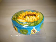A Moorcroft circular based lidded trinket box in the 'Sunflower' pattern, 5 ins diameter (13 cms)