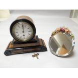 A walnut and ebony drum mantle clock together with a small floral barbola easel mirror