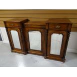 A late Victorian marquetry breakfront credenza, having a trio of mirrored doors interspersed with