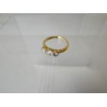 A three-stone diamond ring of believed 18ct yellow gold (hallmarks are worn), visual estimate of