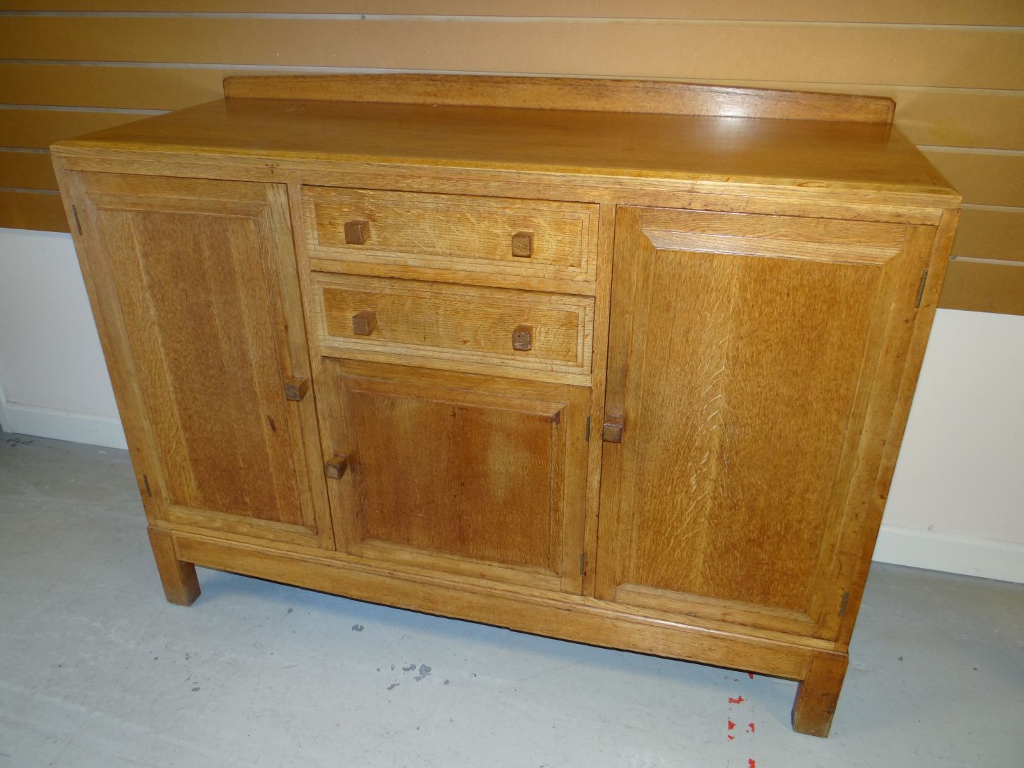 A light oak Brynmawr Furniture 'Talgarth' rail-back panelled sideboard with a combination of two