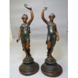 A pair of early twentieth century spelter musician figures on circular wooden bases, 18.5 ins