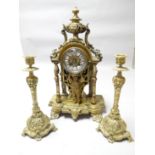 A Rococo style French yellow metal mantle clock with cherubic figure holding aloft the circular dial