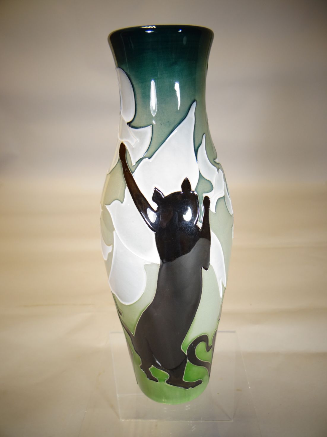 A Moorcroft pottery slender vase in the 'High Jump Cats' pattern, 10 ins high (26 cms)