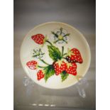 A Moorcroft pottery 'Brittany Strawberries' pattern dish, 4.75 ins diameter (12 cms)