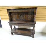 An antique-reproduction Jacobean-style court-cupboard with carved panels and friezes, and having