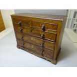 A stained pine apprentice chest of three long and two short drawers with turned knobs having