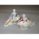 Pair of Meissen figural sweetmeat dishes in the form of a reclining man and lady on scrolling