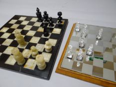 Two twentieth century chess sets, one with etched glass chequerboard, the other with marble board