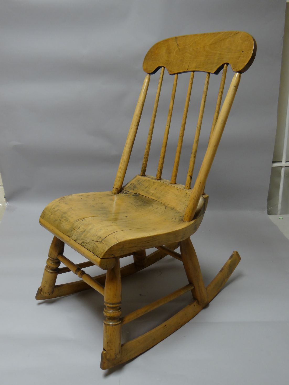 A small primitive New England style rocking-chair with spindle back