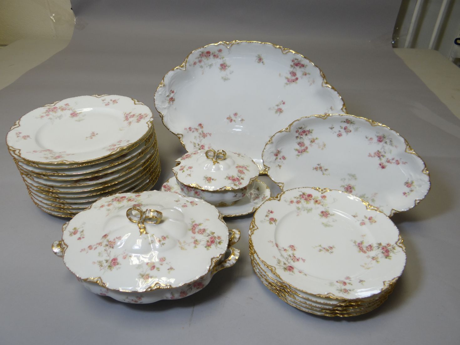 A Limoges floral decorated and gilt porcelain dinner service comprising a large platter, smaller