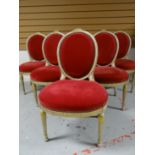 A set of six French-style salon chairs having oval backs and seats upholstered in buttoned red