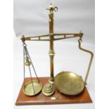 A set of antique brass pharmaceutical scales on mahogany platform base and with brass disc weights