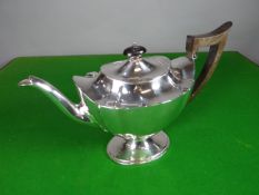 An oval silver pedestal teapot with panelled body and celluloid handle, London 1895, 15.5 ozt,
