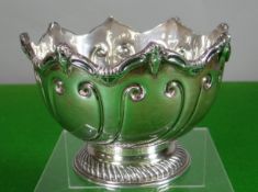 A silver montieth on a circular foot and having swirl decoration to the body and mask crowned rim,