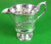 A William IV silver cream jug having a circular footed base, a slightly tapering body and with