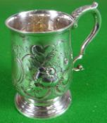 A William IV silver mug of slightly tapering form on a circular footed base and with floral