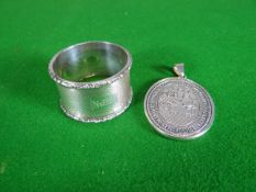An engine turned silver napkin ring, 1.5 ozt; together with a white metal oval school-medal