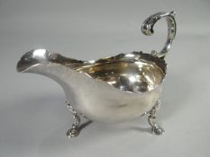 An early-Victorian silver sauce-boat on hoof-supports and with crimped rim and scroll-handle, London