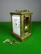 A brass encased striking carriage clock having a white enamel dial bearing Roman Numerals, 5.25