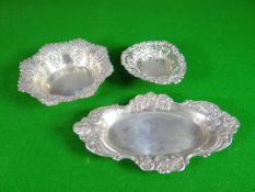 Three small silver pin dishes with decorative borders, 3.69 oz total together with three silver