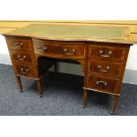 An Edwardian inlaid and crossbanded mahogany desk having a bowed centre drawer flanked by three