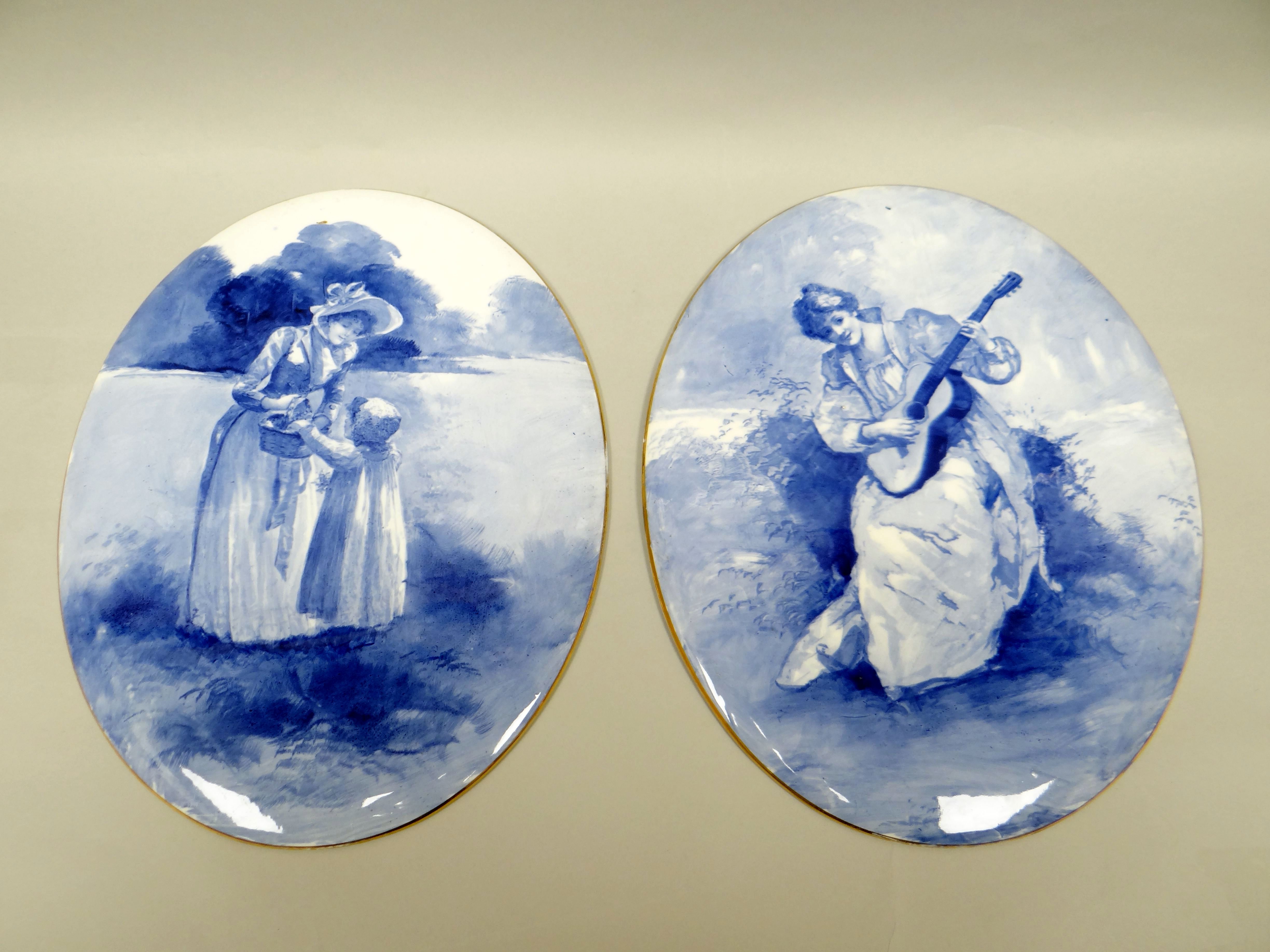 A pair of Royal Doulton blue and white china plaques of oval form, decorated with portraits of a