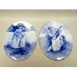 A pair of Royal Doulton blue and white china plaques of oval form, decorated with portraits of a