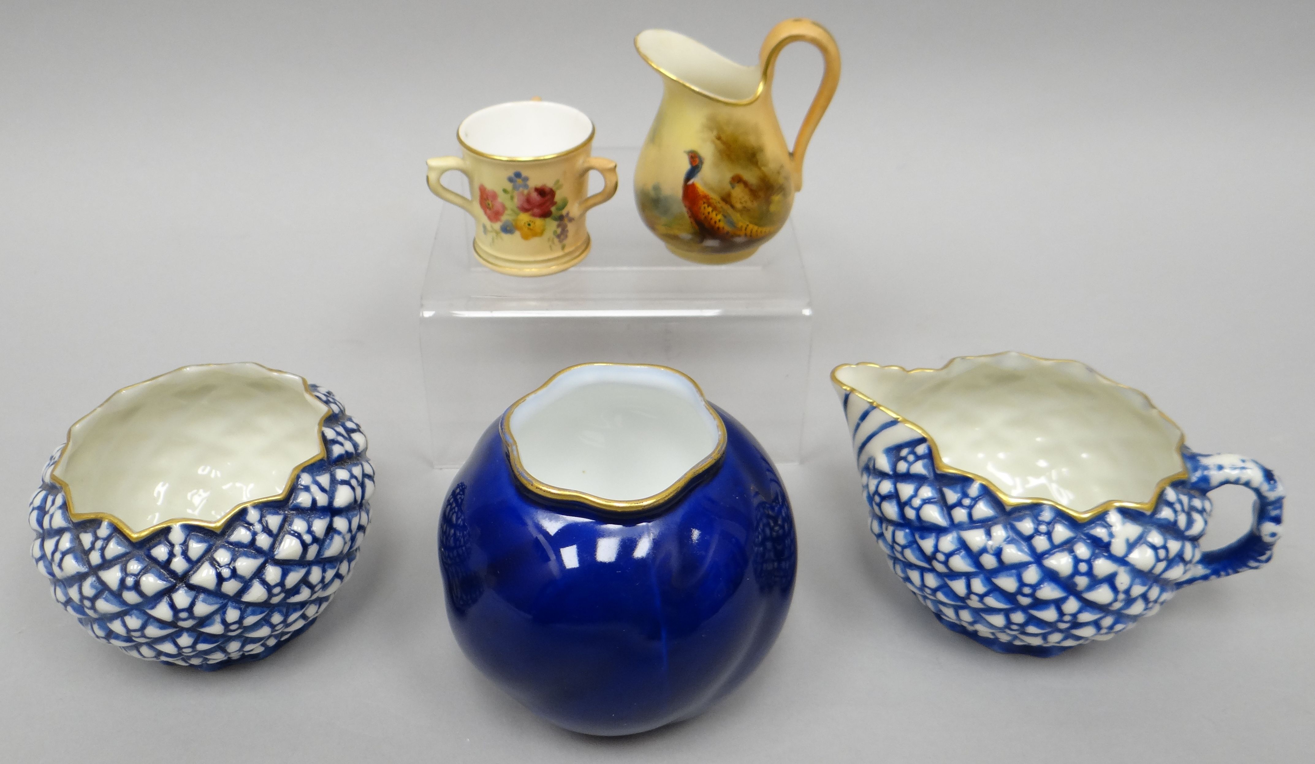 A Locke & Co blue and white cream jug and sugar basin with all-round raised geometric decoration,