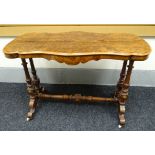 A burr walnut occasional table having a shaped bevelled top above a shaped frieze on turned and