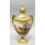 A Royal Worcester covered twin-handled vase with narrow neck on an oval base, painted all-round with