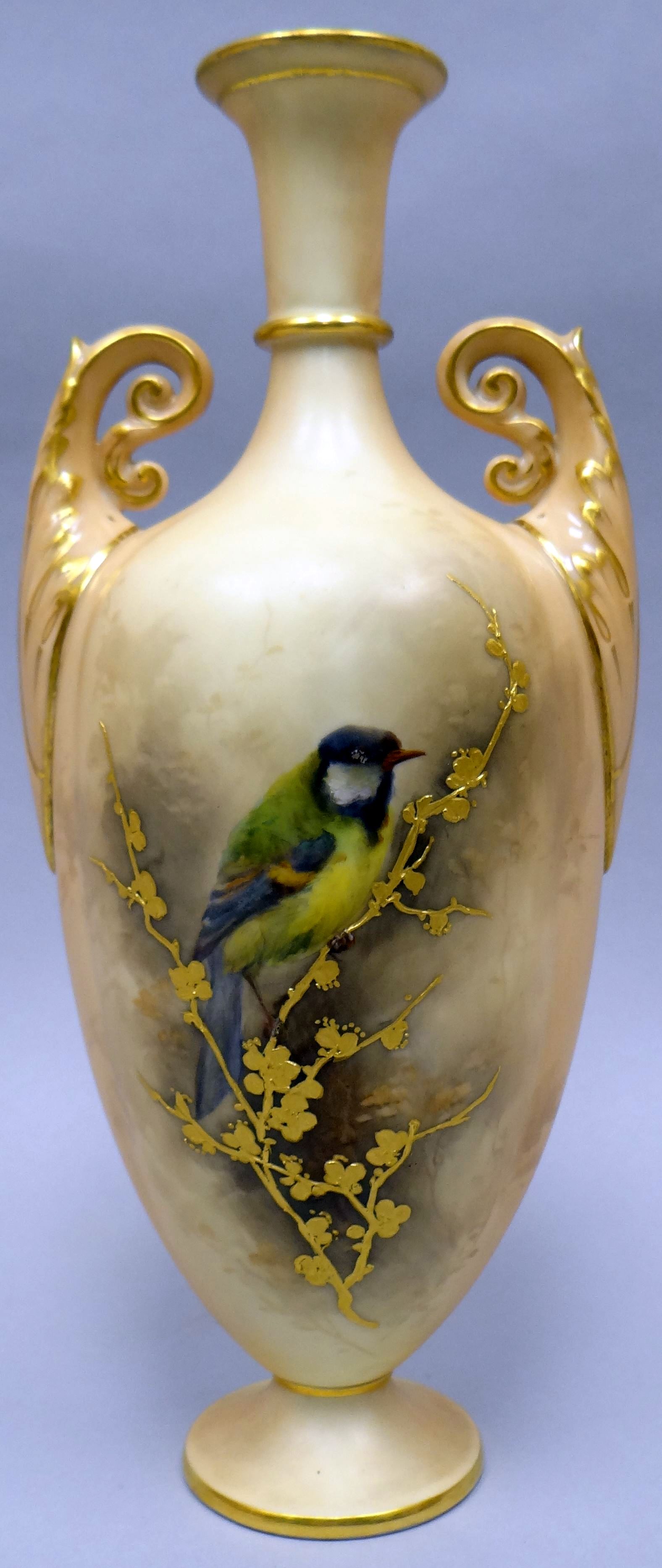 A twin handled Royal Worcester blush ivory narrow necked vase with circular foot, decorated with a