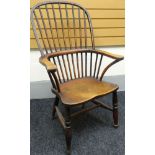 A nineteenth century Windsor elbow-chair with stick and hoop back, shaped arms and on baluster