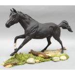 A Royal Doulton horse sculpture of Black Beauty galloping in matt finish on a naturalistic base