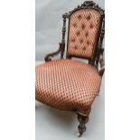 A good Victorian stained open-armchair of elaborate carved form and with classic red diamond-