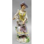 A Ludwigsburg porcelain figure modelled as a bonneted lady in colourful dress and yellow tunic,