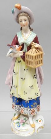 A small Chelsea porcelain figure of a standing lady wearing decorative costume with bird and bird-