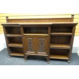 A large open Arts & Crafts stained oak break-front bookcase with adjustable shelves either side of