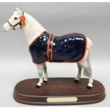 A Royal Doulton horse sculpture 'Welsh Mountain Pony' wearing blue blanket and rosette, on a