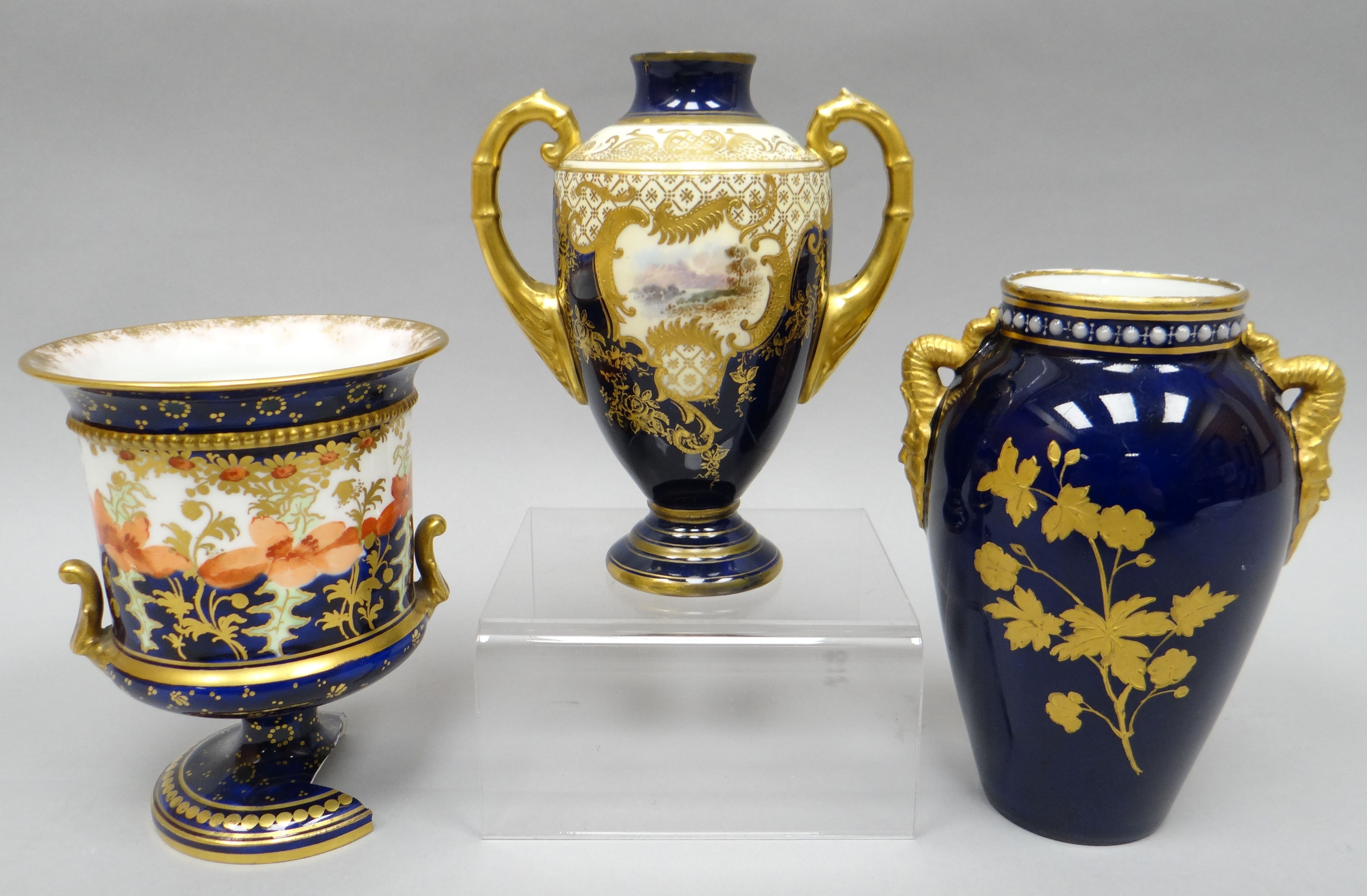 A cream and blue, gilt decorated, twin handled vase, with painted landscapes to opposing sides, 5.
